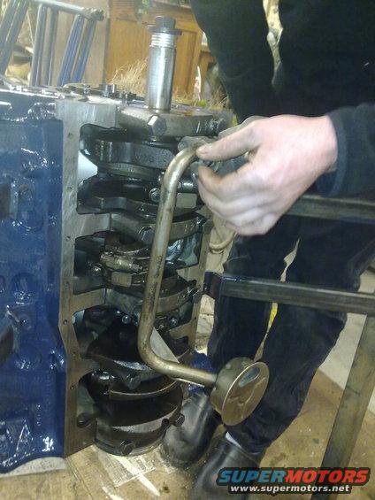 Blue engine block with crankshaft and oil pump assembly being worked on