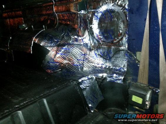 Interior of a vehicle with sound deadening material applied to the rear paneling and floor
