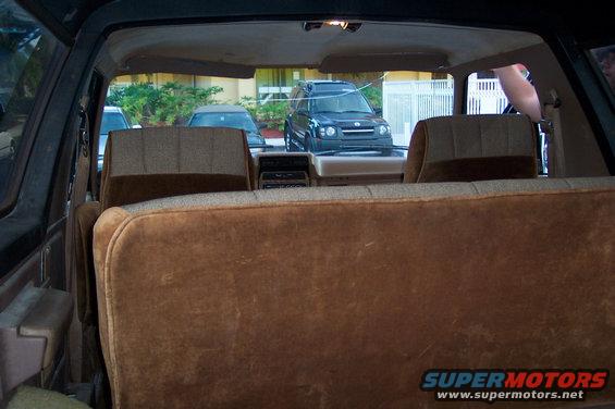 Interior view from rear seat of a 1986 Ford Bronco, looking forward. Another SUV is visible through the windshield