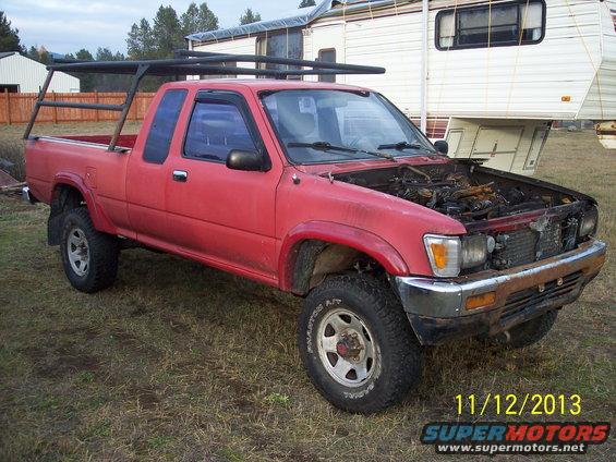 1991 Toyota Pickup/SR5 with a bed rack, hood open, parked outdoors