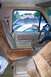 1986 Ford Bronco - The interior of a 1980s SUV, with a view of other vehicles and houses through the window.