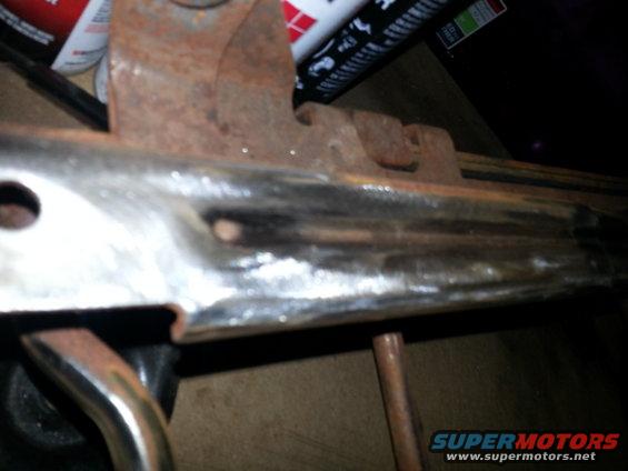 Close-up of a rusty metal seat bracket with chrome trim