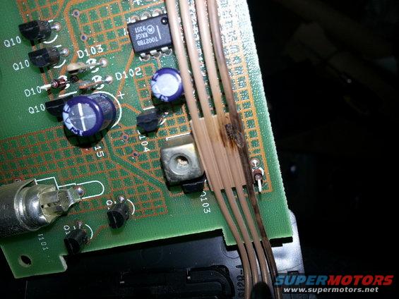 Close-up of a burnt electronic circuit board with wires and components