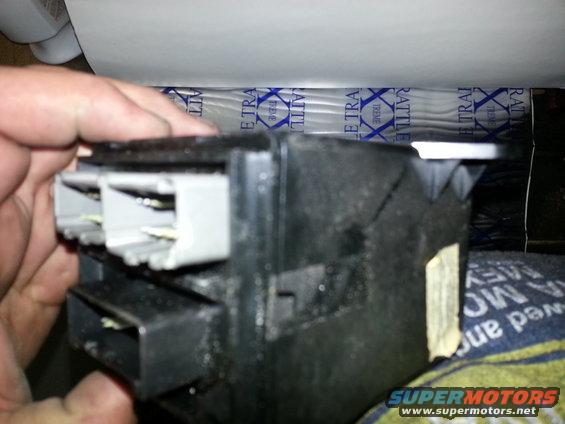 hand holding black plastic electrical connector with gray plugs