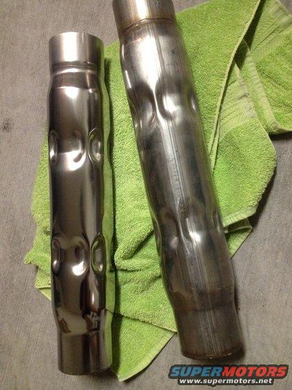 Two dented exhaust pipes on a green towel