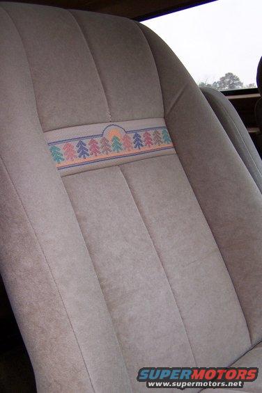 Close-up of a car seat with a patterned fabric band trees and a sun