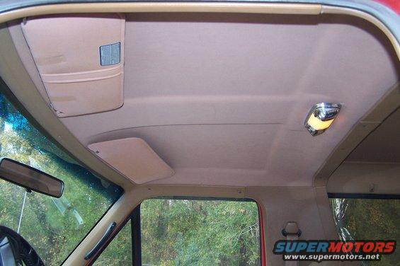 Interior ceiling of a 1990 Ford Bronco with tan headliner, sun visors, dome light, and rearview mirror
