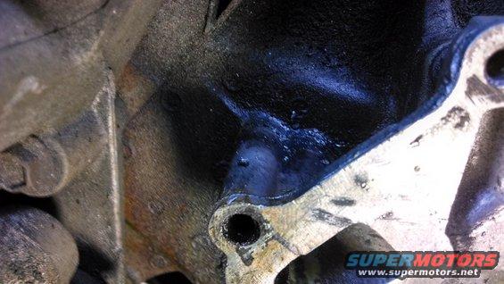 Close-up of cast metal engine block with some oil residue