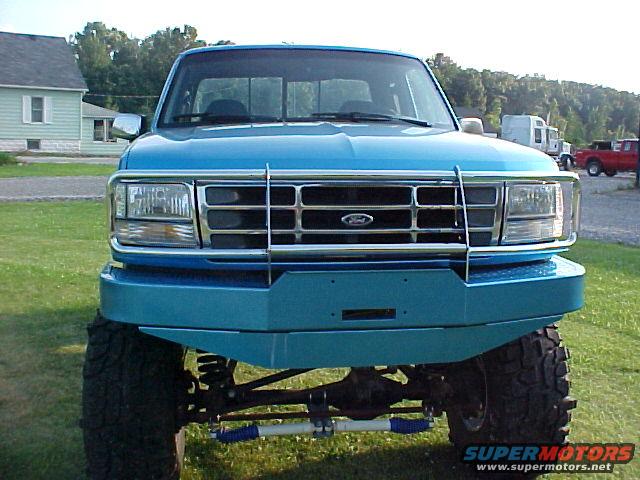 Front view of a lifted blue 1992 Ford F-150 with a custom bumper