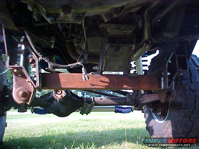 Underside view of a truck's rear axle, suspension components, and frame