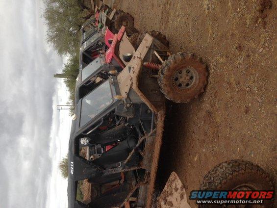 Mud-covered off-road vehicle with exposed interior and large tires