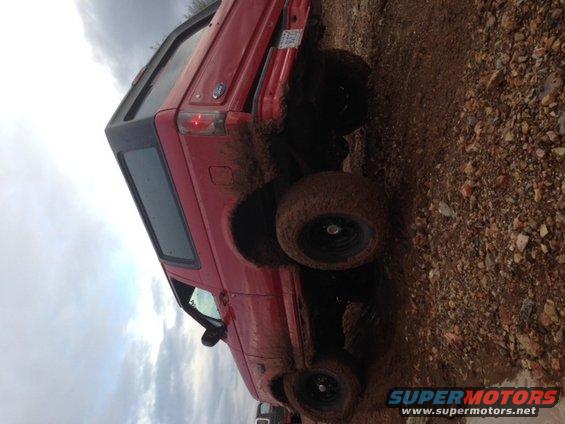 Red 1996 Ford Bronco in mud, 3q-front view