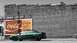 1993 Ford Taurus - A green sedan is parked in front of a brick building a vintage Coca-Cola advertisement.