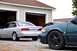 1993 Ford Taurus - A silver 1992 Ford Taurus is parked next to a dark green Ford Taurus in front of a garage.