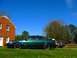 1993 Ford Taurus - A green 1993 Ford Taurus sedan is parked on a grassy lawn next to a brick house.