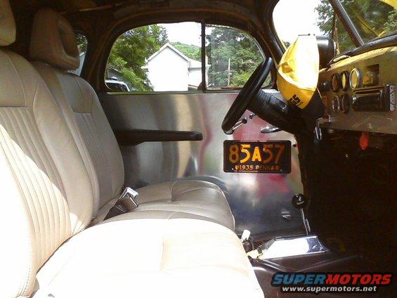 Interior view of a 1935 Chevrolet New with beige seats and a license plate reading 85A57
