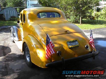 Yellow 1935 Chevrolet New coupe, rear view with American flags