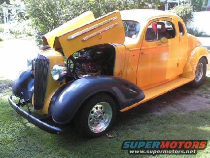 Yellow 1935 Chevrolet New coupe, hood open, showing engine