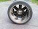 2004 Chrysler Crossfire - A single wheel and tire assembly is shown from the side, resting on asphalt.