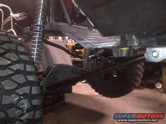 Off-road vehicle suspension with large tire, shock absorber, and differential visible