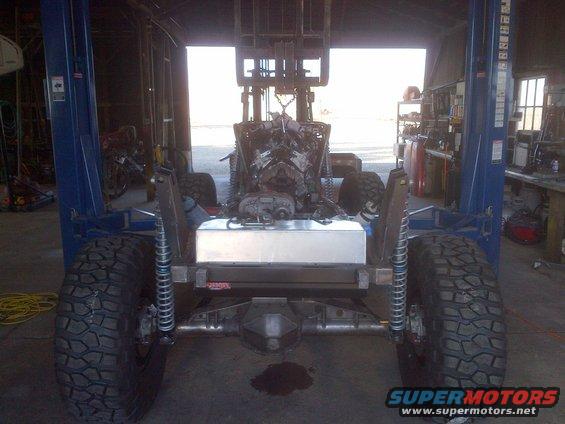 1985 Jeep CJ7 frame with engine and fuel tank visible, on a lift