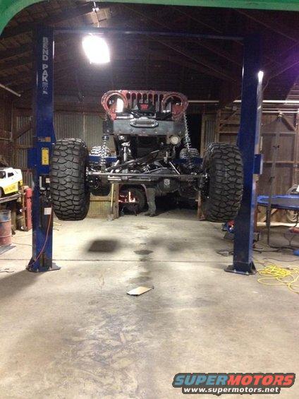1985 Jeep CJ7 body on a lift, front view, with large off-road tires
