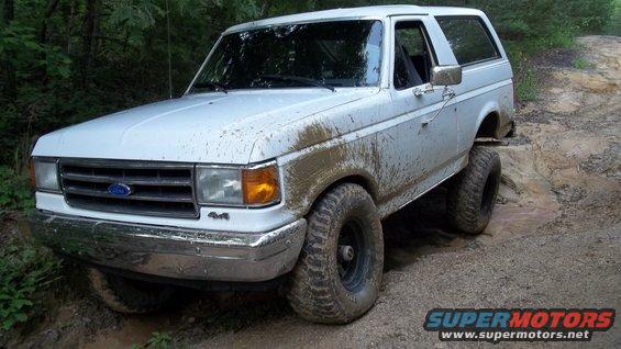 White 1990 Ford Bronco on a muddy trail