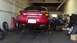 1996 Ford Taurus - A red 1996 Ford Taurus is shown from the rear in a garage, possibly undergoing maintenance.