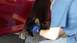 1996 Ford Taurus - A person in blue gloves is working on the brake assembly of a red vehicle.