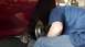 1996 Ford Taurus - A person works on the rear brake rotor and caliper of a red 1996 Ford Taurus.