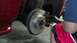 1996 Ford Taurus - A person in black gloves works on replacing the brake rotor on a red vehicle.
