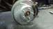 1996 Ford Taurus - Close-up view of a new drilled and slotted brake rotor with pads and caliper installed.
