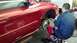 1996 Ford Taurus - Mechanic working on the brake rotor of a red 1996 Ford Taurus.