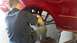 1996 Ford Taurus - A person is working on the brake system of a red vehicle, likely replacing a rotor.