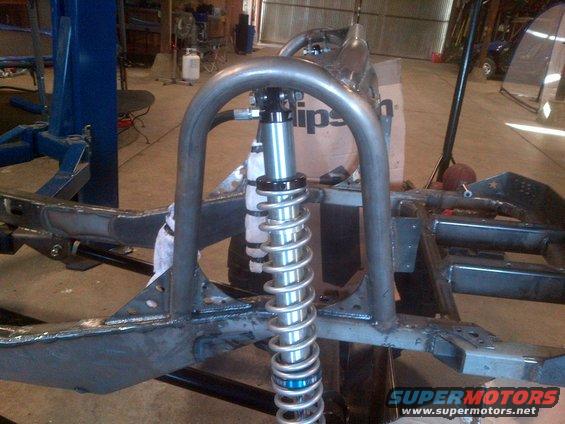 Custom off-road vehicle frame with a large coilover shock absorber mounted to a roll cage structure