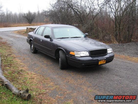 Dark gray 2003 Ford Crown Victoria parked on a gravel driveway