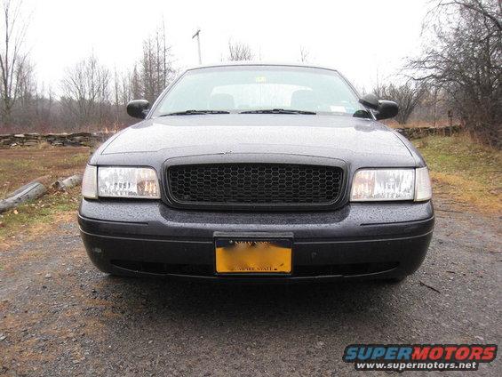 2003 Ford Crown Victoria front view with black honeycomb grille and New York license plate