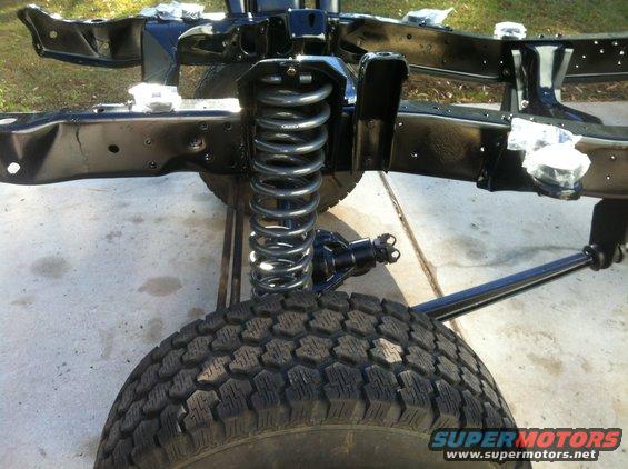 close-up of vehicle frame with front suspension and tire