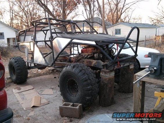 Custom buggy frame with large tires and exposed engine, undergoing construction