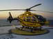 1992 Ford Bronco - A yellow helicopter sits on a helipad near the ocean at sunset.