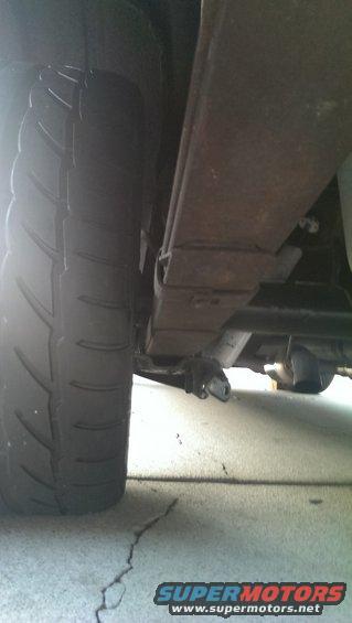 Close-up of a vehicle's rear tire and leaf spring suspension system