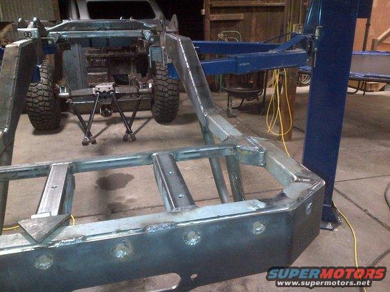 Jeep CJ frame with suspension components and tires visible