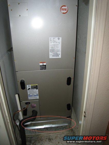 Payne HVAC unit with visible labels and some handwritten text on the floor