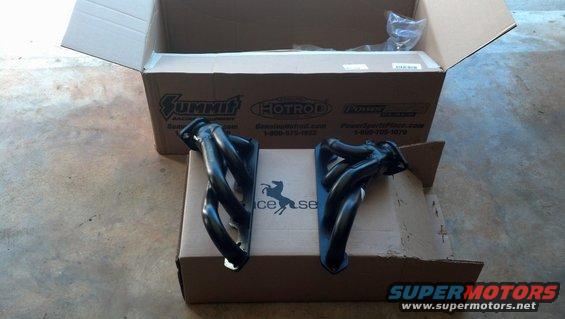 Pair of black exhaust headers on cardboard boxes, Summit Racing logo visible