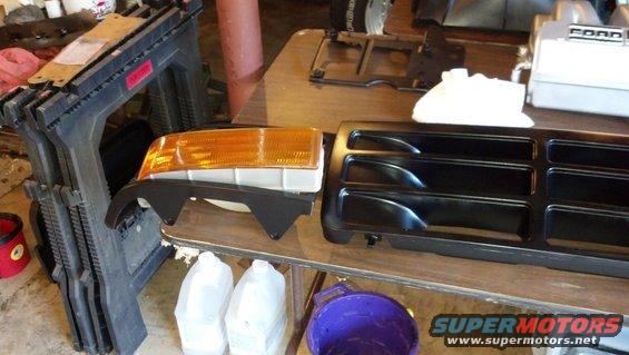 Black Ford Bronco grille and amber headlight assembly on a table