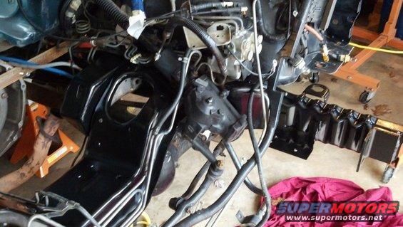 vehicle frame and engine parts on jack stands, looks like it's being worked on