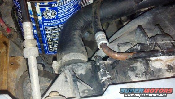 Close-up of engine bay with hoses, a Maxwell House coffee can, and part of a radiator