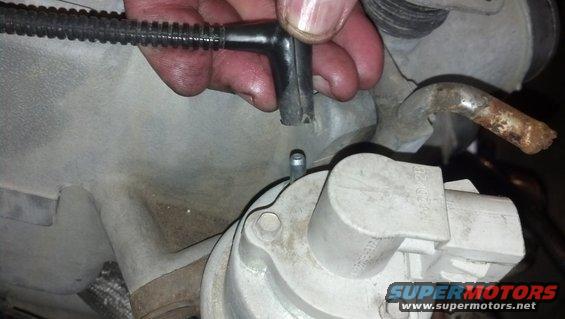 Engine part with disconnected vacuum hose and rusty metal tube