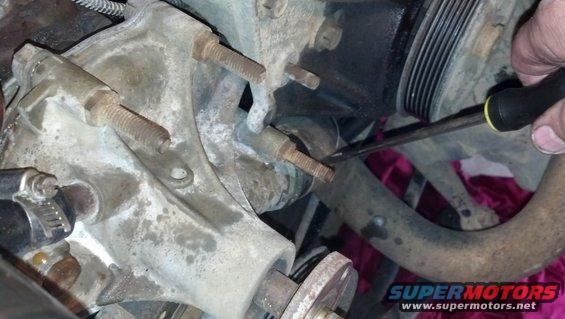 close-up of engine water pump with bolts and pulley