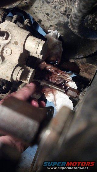 Hand wiping greasy engine component with a white rag